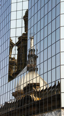 Fototapeta premium Reflexo de um predio na parede de vidro do outro lado da rua em Santiago
