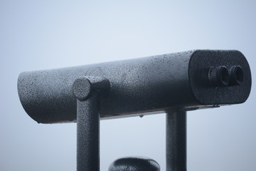Binoculars to observe the sights on a background of white fog.