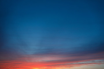 Obraz premium Dramatic sunset sky background with fiery clouds, yellow, orange and pink colour, nature background. Beautiful skies