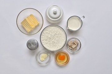 Ingredients for yeast dough. Each in a separate container. Top view, group in the center, on a light background.