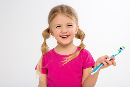 Happy little girl standing with toothbrush isolated on white.little child brush his teeth.Cute little girl is brushing teeth with a smile.dental hygiene. happy little girl brushing her tooth