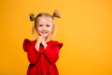 baby girl portrait isolate yellow background.Stylish little baby with hands up. Portrait of shocked...