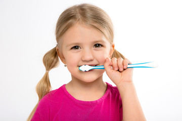 Happy little girl standing with toothbrush isolated on white.little child brush his teeth.Cute little girl is brushing teeth with a smile.dental hygiene. happy little girl brushing her tooth