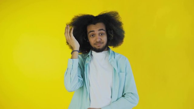Disappointed afro american male doing facepalm gesture against yellow background. Concept of emotions