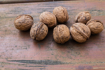unopened walnuts, with wooden bottom and green trees