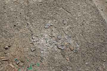 broken glass on asphalt surface. street vandalism in the city. pieces of broken glass on asphalt concrete road.