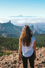 young tourist woman from behind in front of el teide volcano of tenerife on gran canaria, canary islands