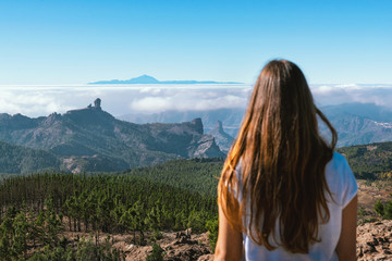 young tourist woman from behind in front of el teide volcano of tenerife on gran canaria, canary islands