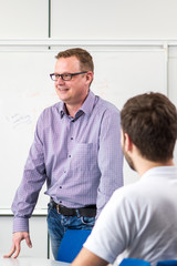 Fototapeta premium Young teacher explaining english grammar. Study english.