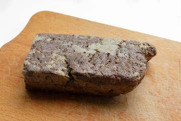 close-up of sunflower seed Halva dessert with sesame paste and cacao on a wooden cutting board .