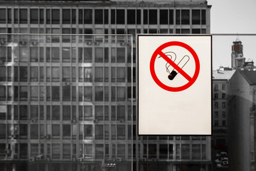 no smoking sign on the white placard with copy space for text, city in the background.