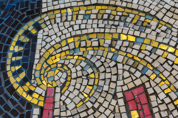 fragment of ancient multi-colored mosaic, mosaic vortex texture. Vibrant mosaic of tiles as a background image.