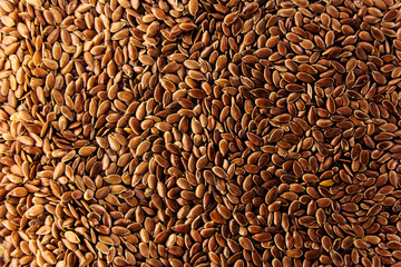 Brown flax seeds give flaxseed oil background