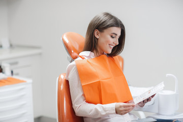 Dental clinic. Reception,examination of the patient. Teeth care. Young girl smiling, looking in the...