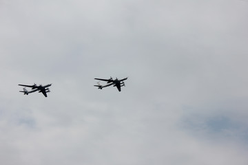 Fototapeta na wymiar Two aircrafts of russian armed forces flying on cloudy sky background in St. Petersburg, Russia
