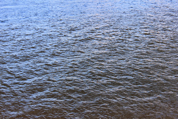 Water surface background. River water close up top view with small waves