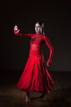 Young hispanic flamenco dancer in red dress isolated on black background