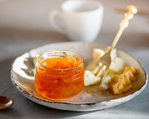 Fruit jams and marmalades in  jars, cheese on a plate. Breakfast with tasty snacks