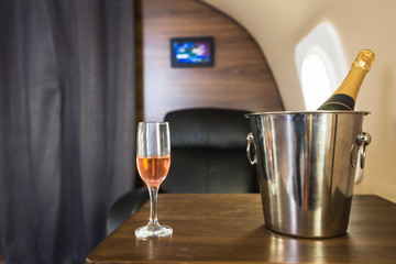 A glass of champagne in the interior of a private jet. Flying first class