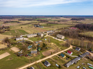 aerial view of country roads and small village with houses and lake