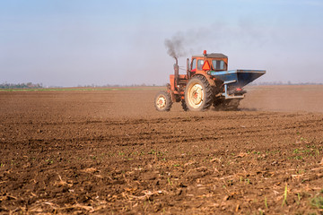 Tractor spraying a soil with fertilizer. Fertilization of soil. Early spring time.