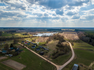 Fototapeta premium aerial view of country roads and small village with houses and lake