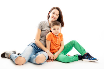 Mom and son hug and smile. White background.