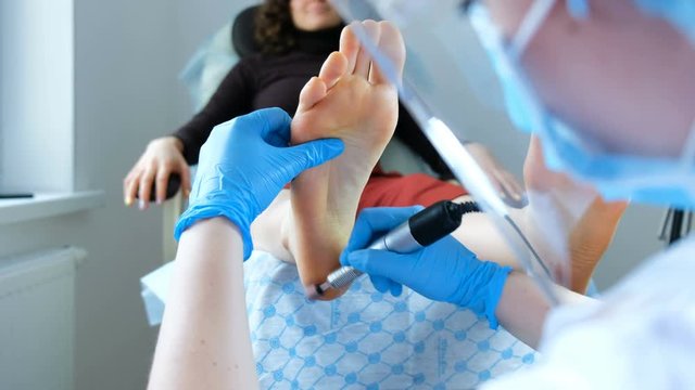 Medical hardware pedicure - pedicure master makes peeling on client's feet