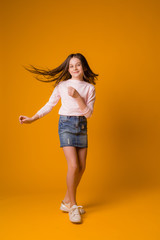 kid girl jumping happy girl dancing on yellow background