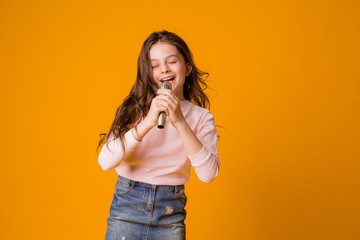 baby girl with microphone smiling singing,Fat girl singing song into microphone. Young star,...