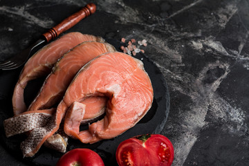 Raw salmon, tomatoes and salt on marble table. Fresh fish. Red fish. Sashimi. Sushi. carpaccio. Seafood.