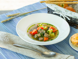 Bowl of beef soup and vegetables on the table in blue