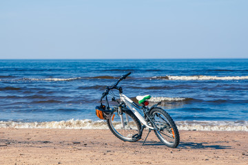 Obraz premium Bicycle parked on Baltic beach next to water in spring