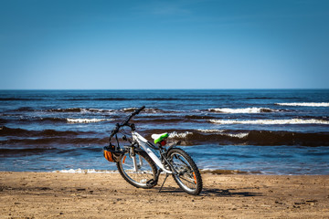 Bicycle parked on Baltic beach next to water in spring