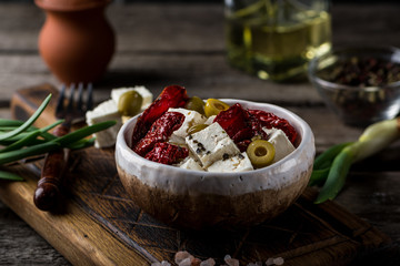 Greek cheese feta with herbs and olives, sundried tomatoes. Bulgarian cheese. Feta in oil. Olove oil. selective focus. appetizer