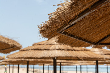 Fototapeta na wymiar Straw umbrellas on the beach