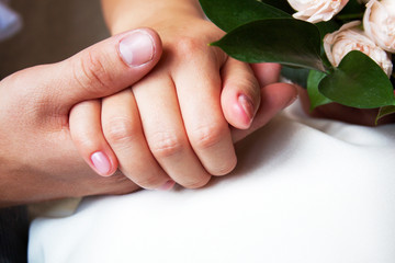 couple holding hands with woman's hand on top of man's hand