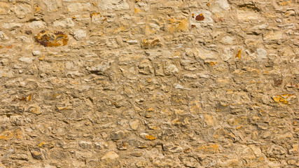 Background of old stone wall. The texture of the stone surface. Brickwork in the old European city. Pattern in retro style