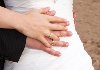 couple holding hands with woman's hand on top of man's hand