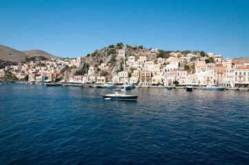 Fototapeta na wymiar The pier and the picturesque seafront of Symi.