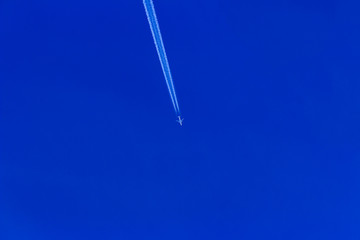 Contrail from a jet aircraft flying diagonally overhead