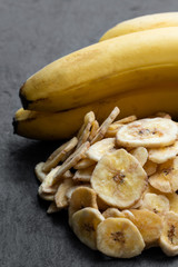 Homemade dehydrated banana chips isolated on stone background