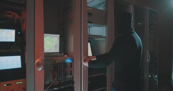 hacker in mask get in data centre and begin work