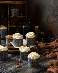 Delicious homemade carrot cupcakes in blue paper cups with white beautiful icing 