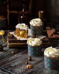 Delicious homemade cut of carrot cupcakes with white beautiful icing and orange filling 