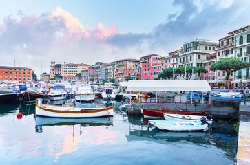 Santa Margherita Ligure, Italy. Genoa area. Picturesque sunset scenery of Italian Ligurian sea shore, boats and yachts at foreground and old Mediterranean architecture with epic sky in background.