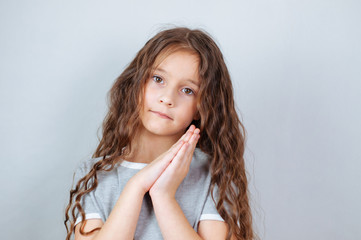 Studio emotional portrait of a serious little girl with long hair