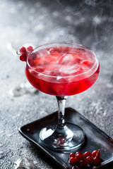 red cocktail with ice vapor. Cocktail with smoke. Alcohol drink, vodka, ice, party, dry ice.