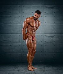 Handsome Competitive Bodybuilder Flexing Muscles. He is showing Side Triceps Pose
