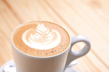 cup of cappuccino on the wooden background